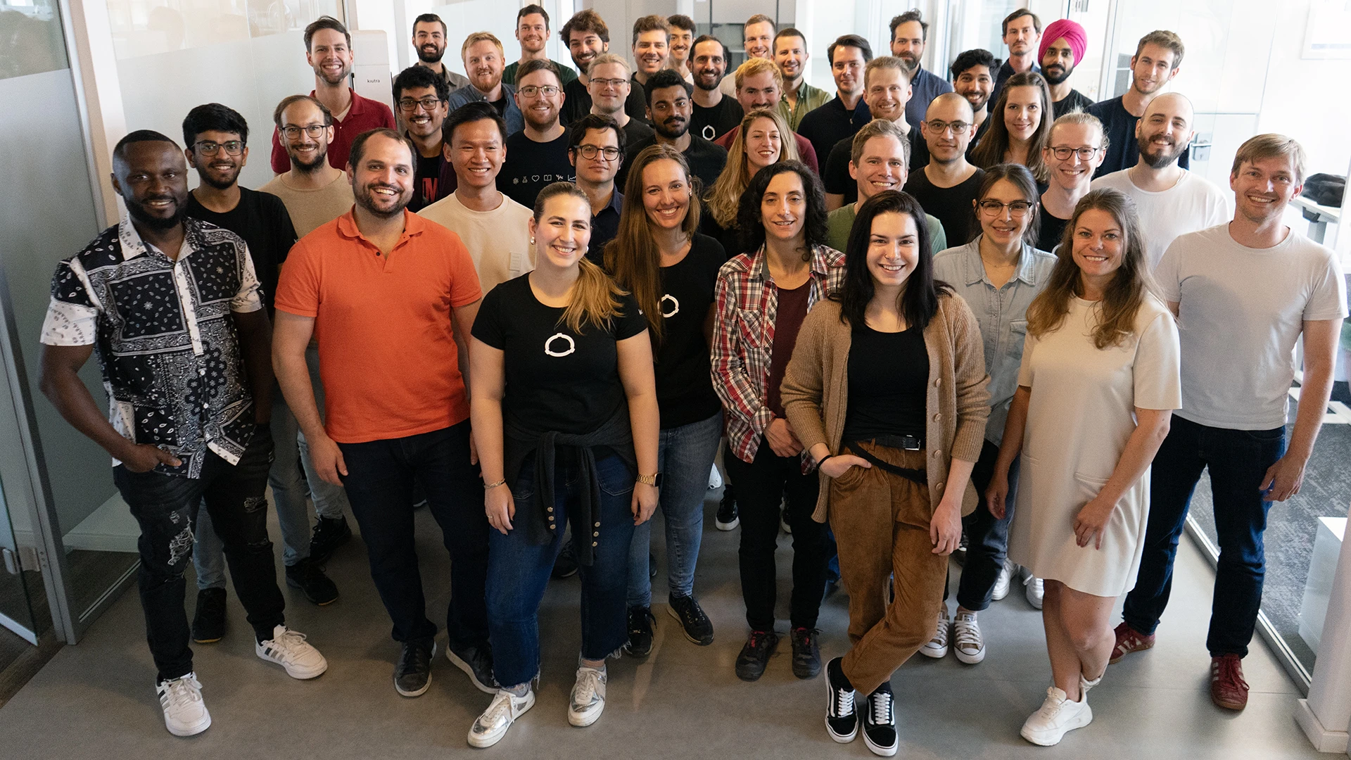kiutra team gathered in the Munich office, several wearing kiutra-branded T-shirts.