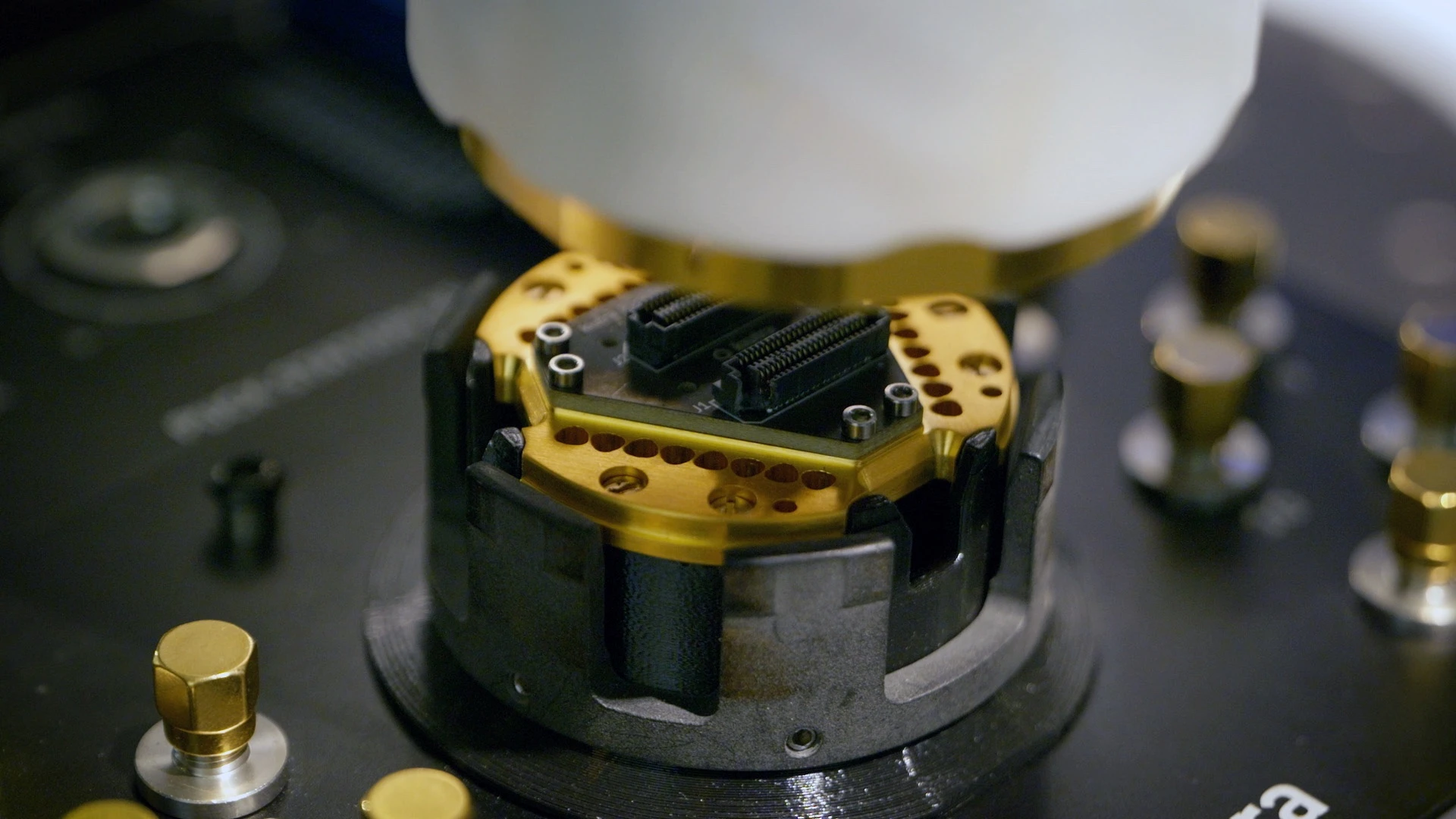 Close-up of a kiutra sample puck station with a gold-plated sample carrier
