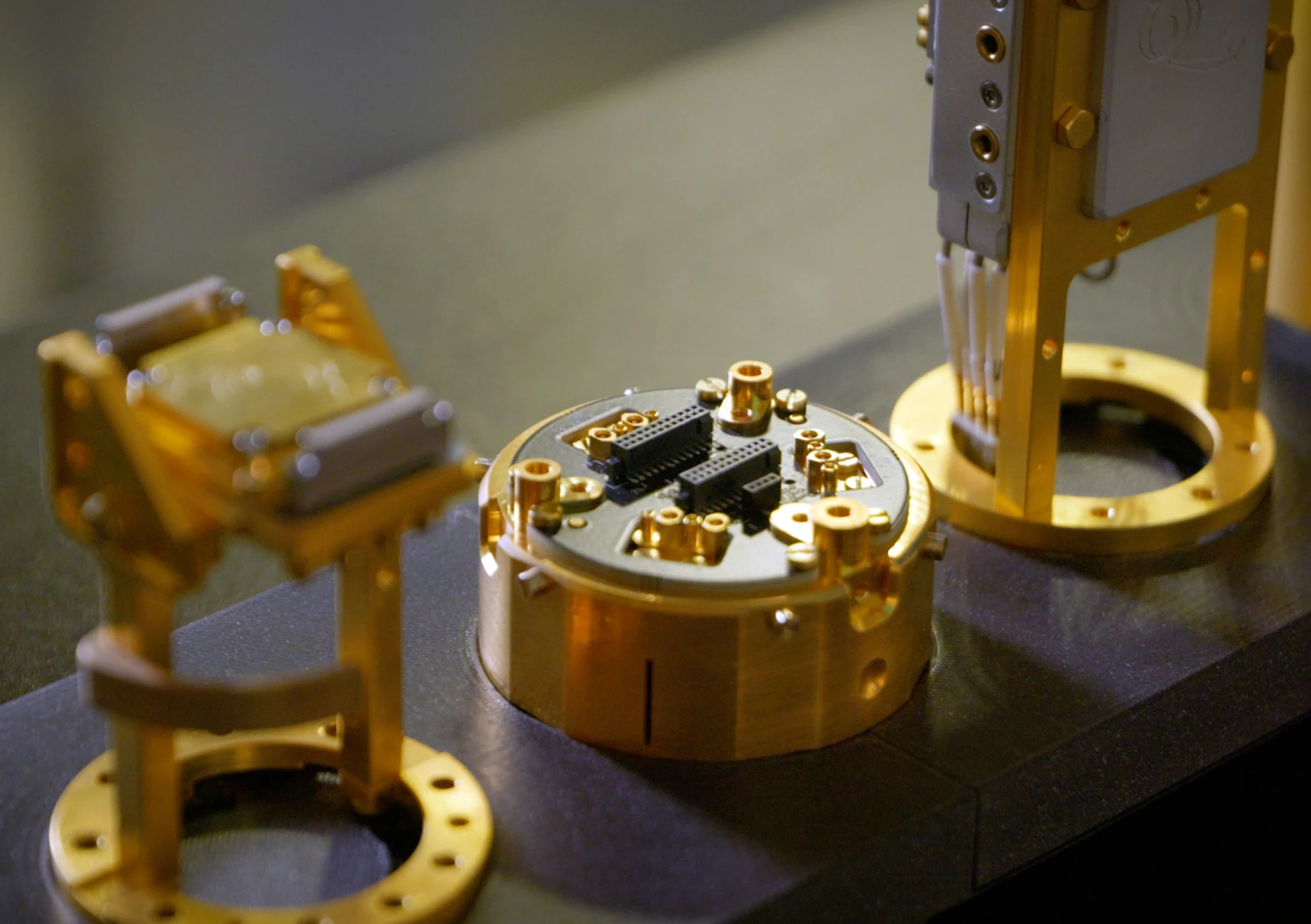 Gold-plated sample holders and a loaded sample puck on a kiutra cryostat bench