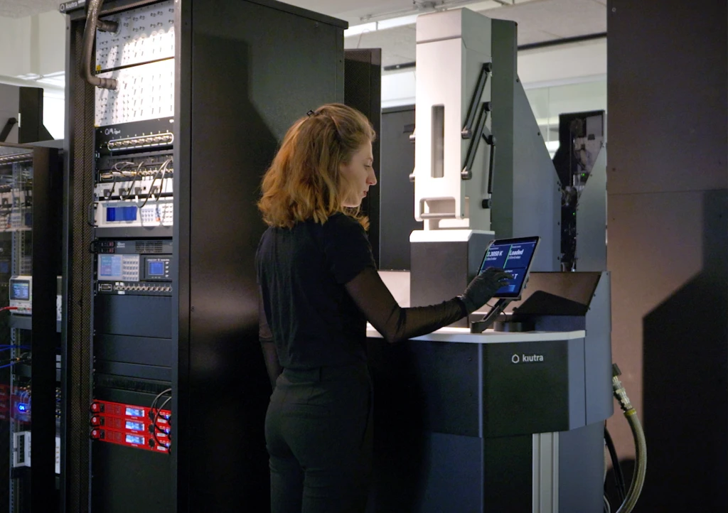 kiutra employee operating a cryostat's touchscreen control panel, temperature reading displayed.